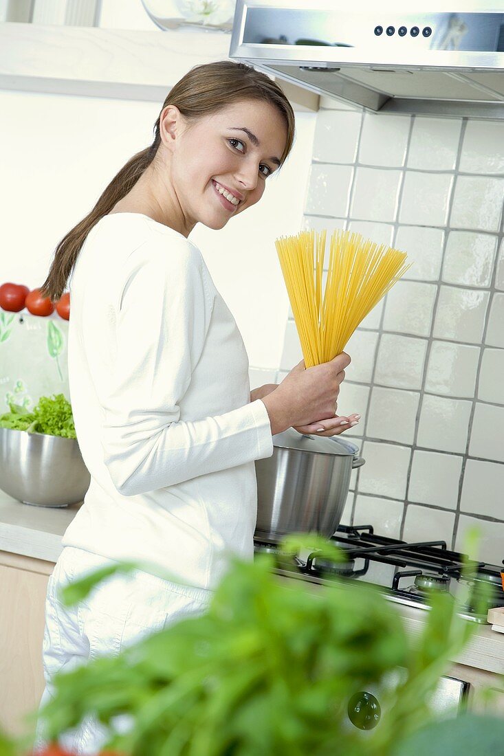 Woman holding a bundle of spaghetti in her hands