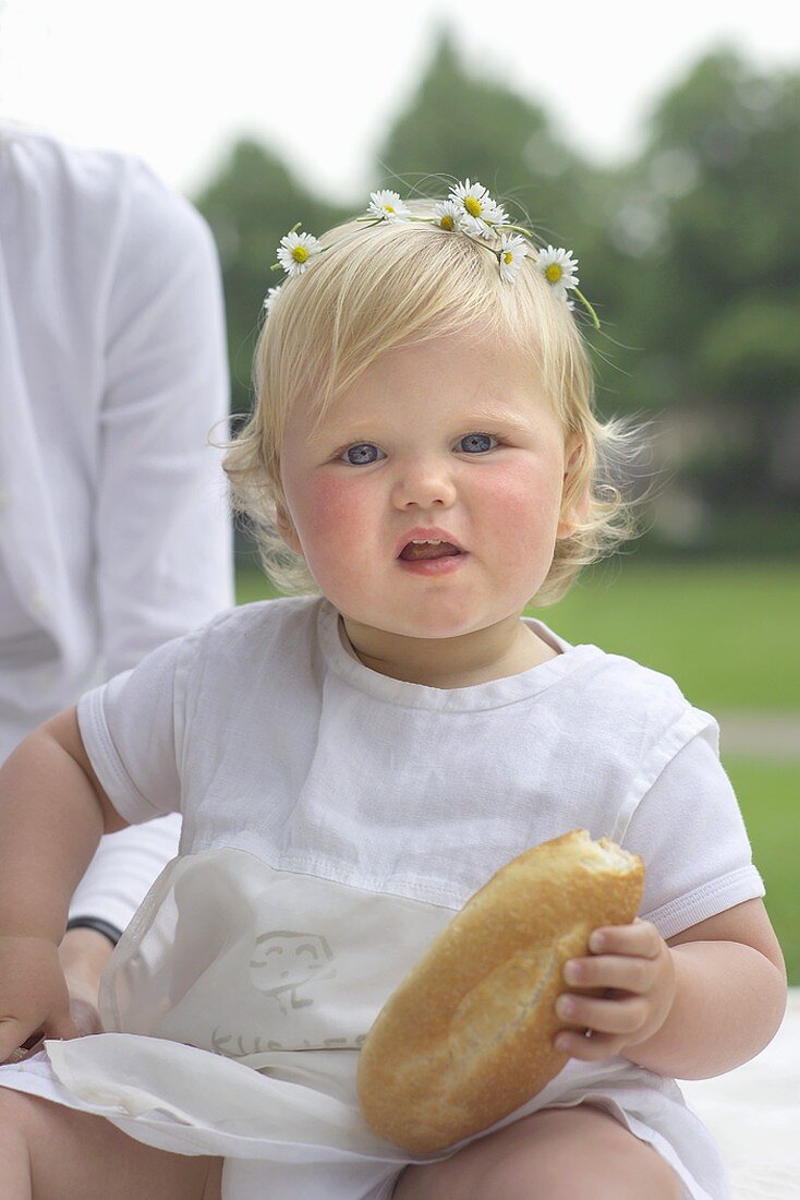 Small girl with bread roll in her hand