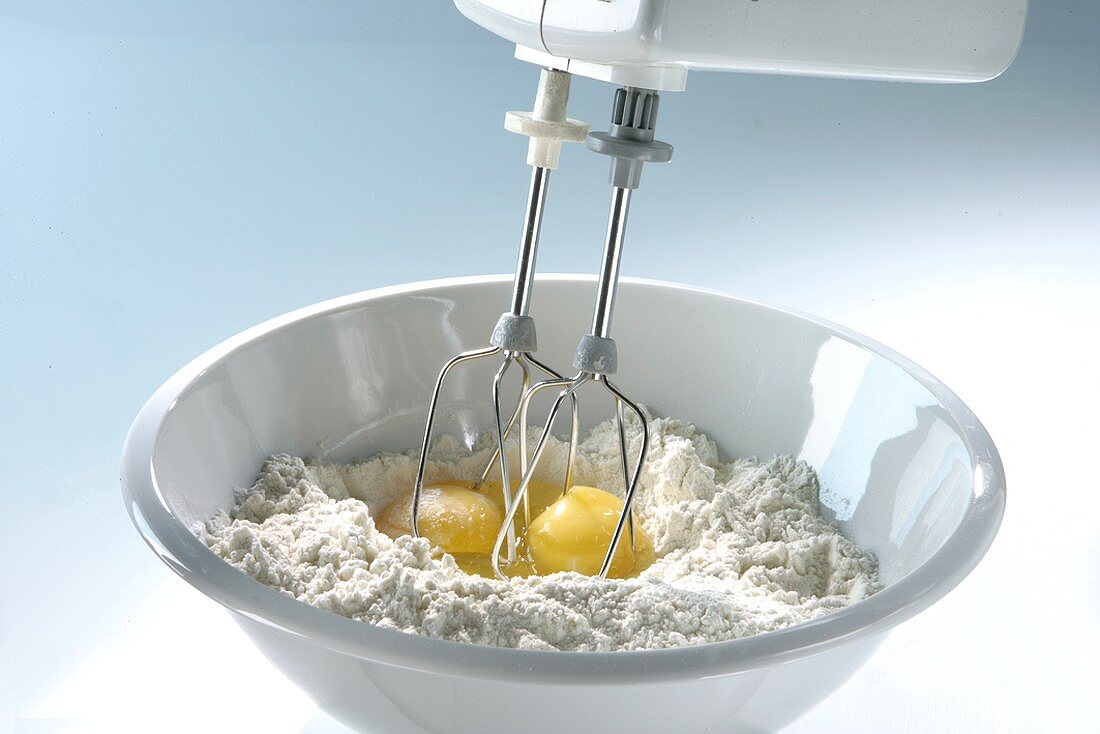 Mixing flour and eggs with an electric hand mixer