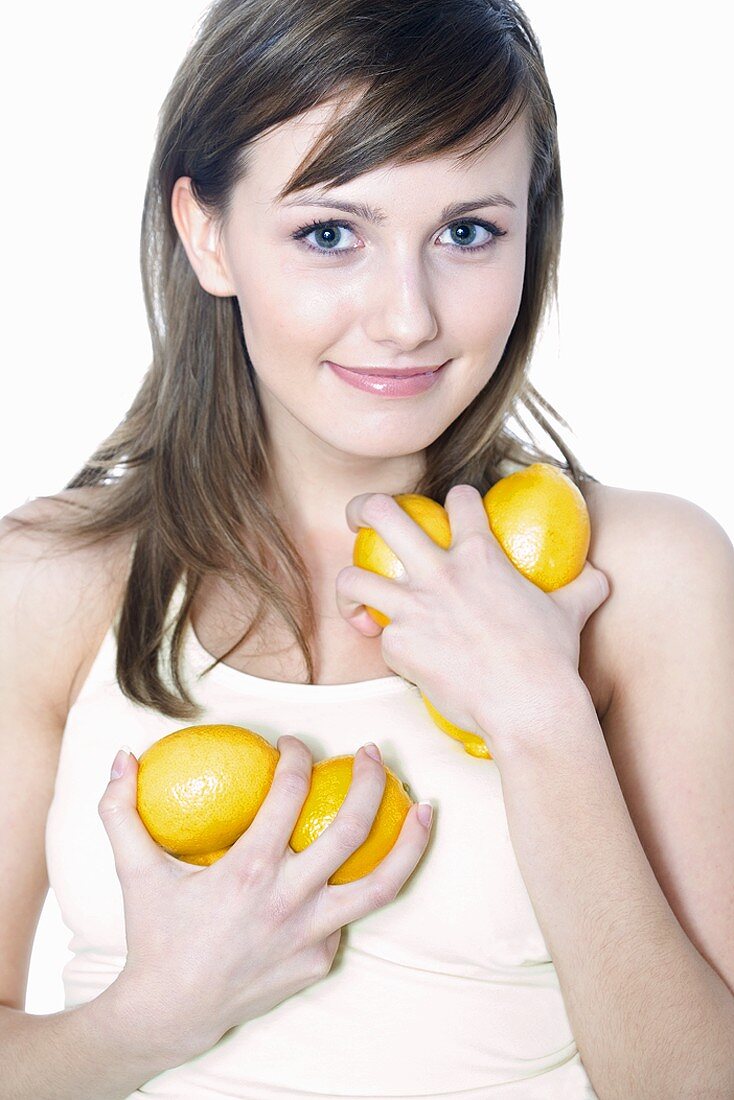 Young woman holding fresh lemons in her hands