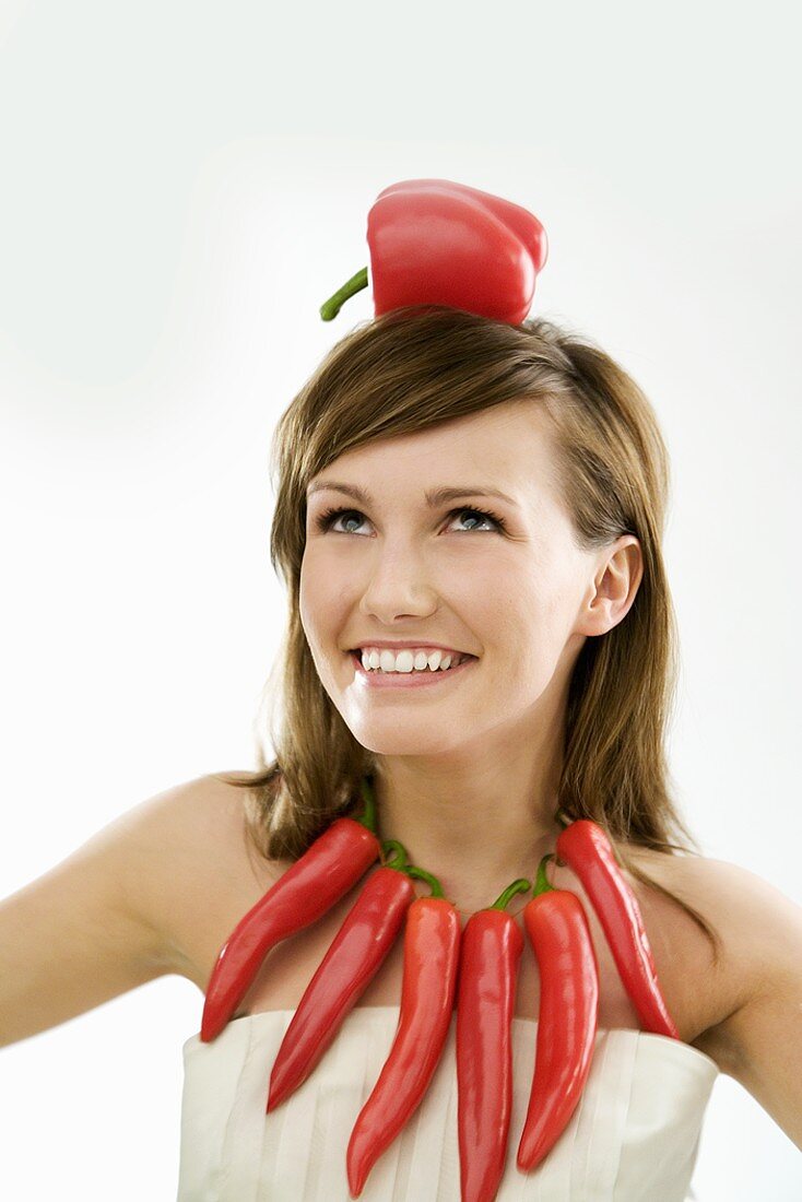 Young woman with necklace of chillies and pepper