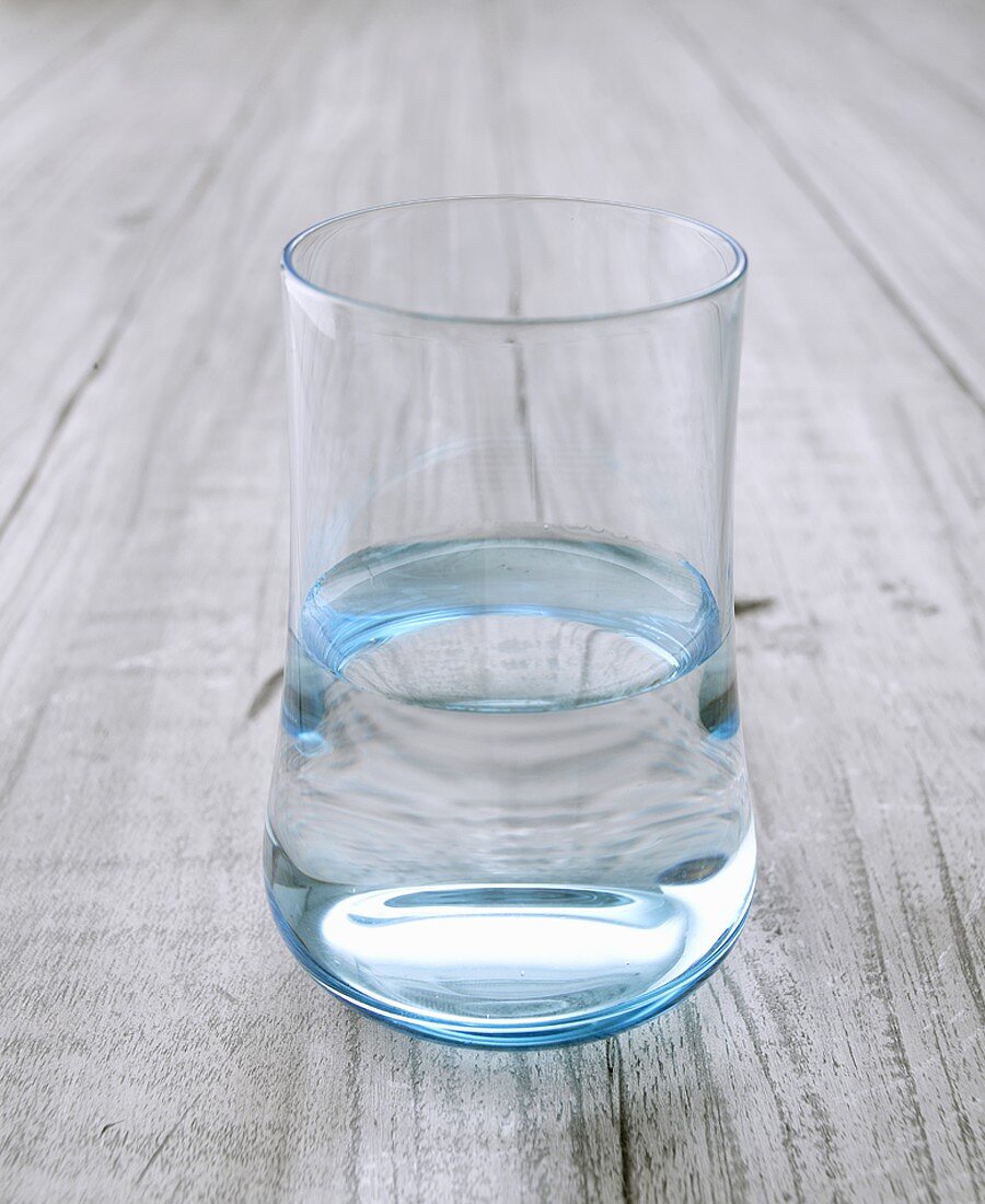 Glass of water on wooden background