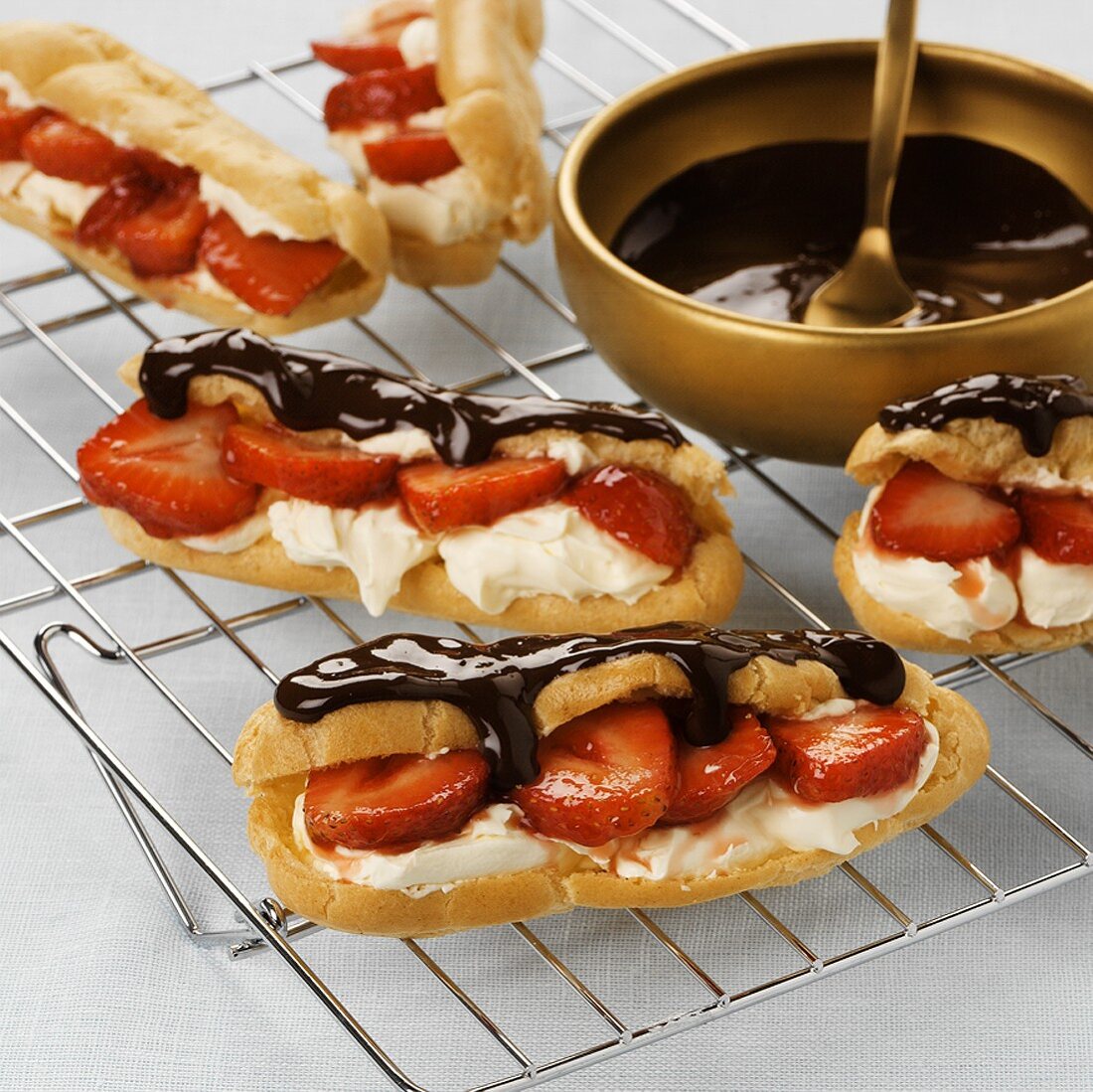 Chocolate eclairs with strawberry and cream filling