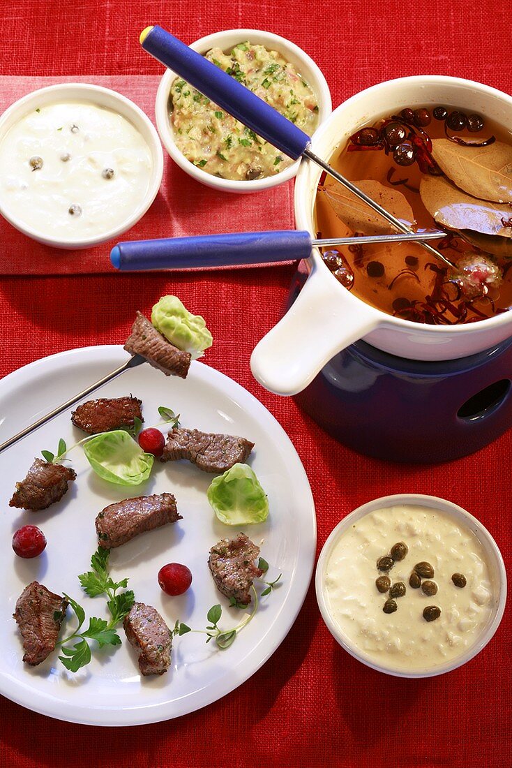 Meat fondue with broth and a selection of dips
