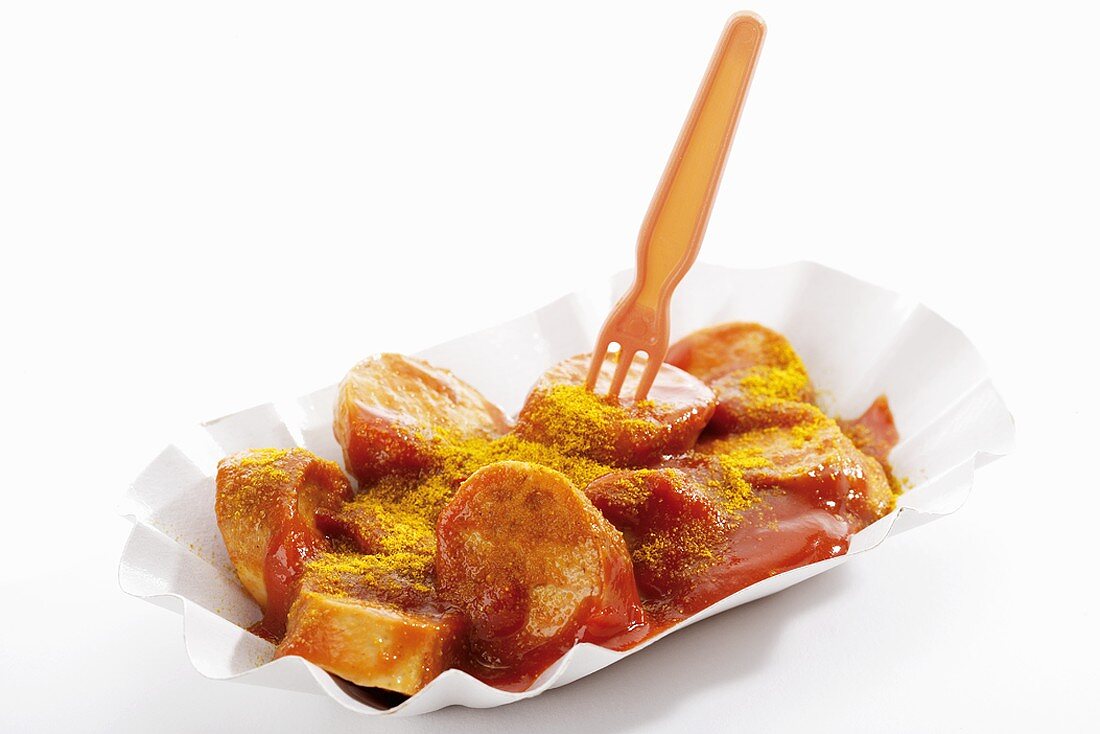 A currywurst (sausage with ketchup & curry powder) in paper dish