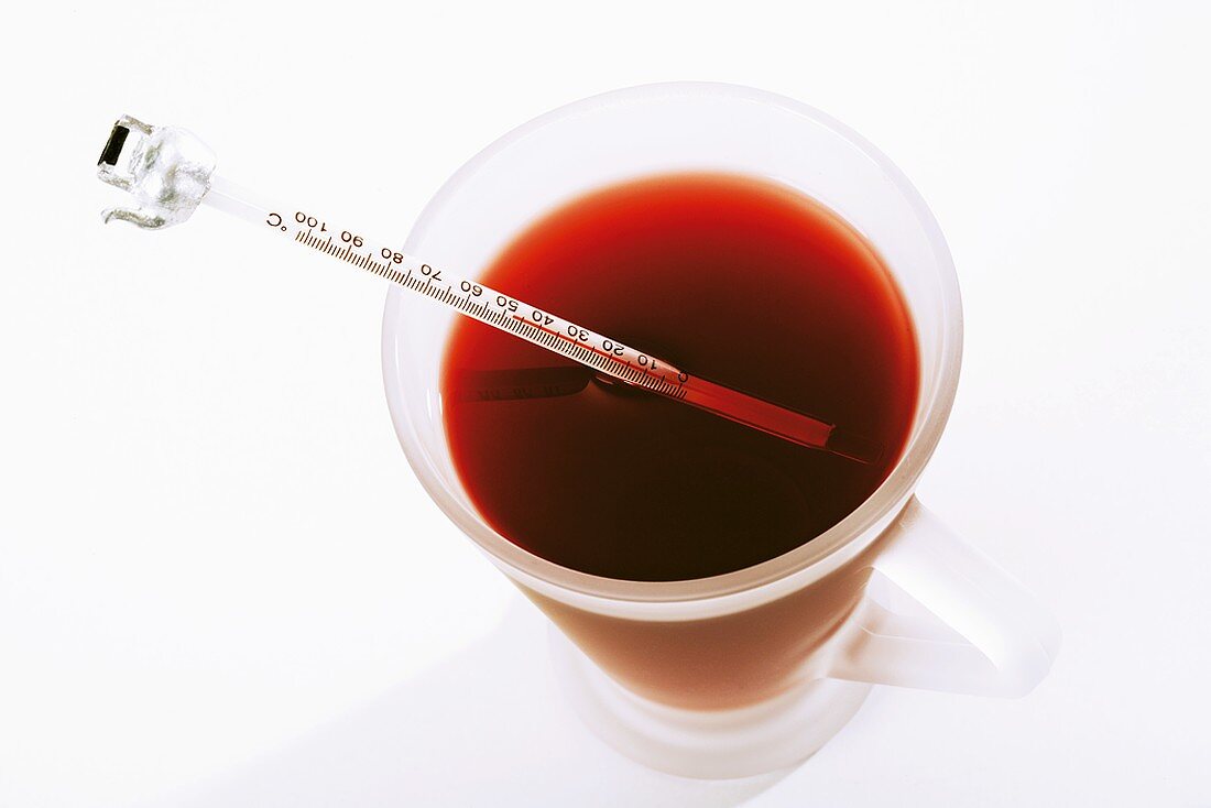 Ein Glas Tee mit einem Thermometer