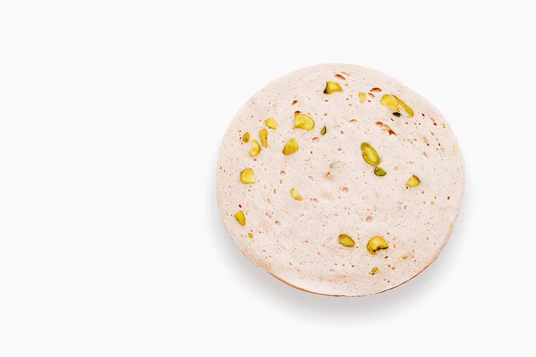 A slice of veal sausage with pistachios