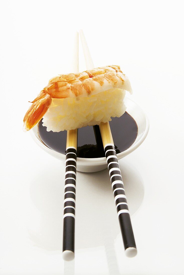 Nigiri-Sushi mit Garnelen, Sojasauce und Essstäbchen