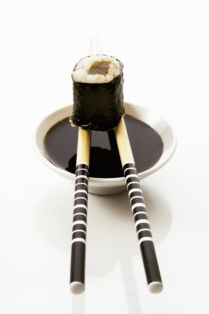 Tuna maki sushi with soy sauce and chopsticks