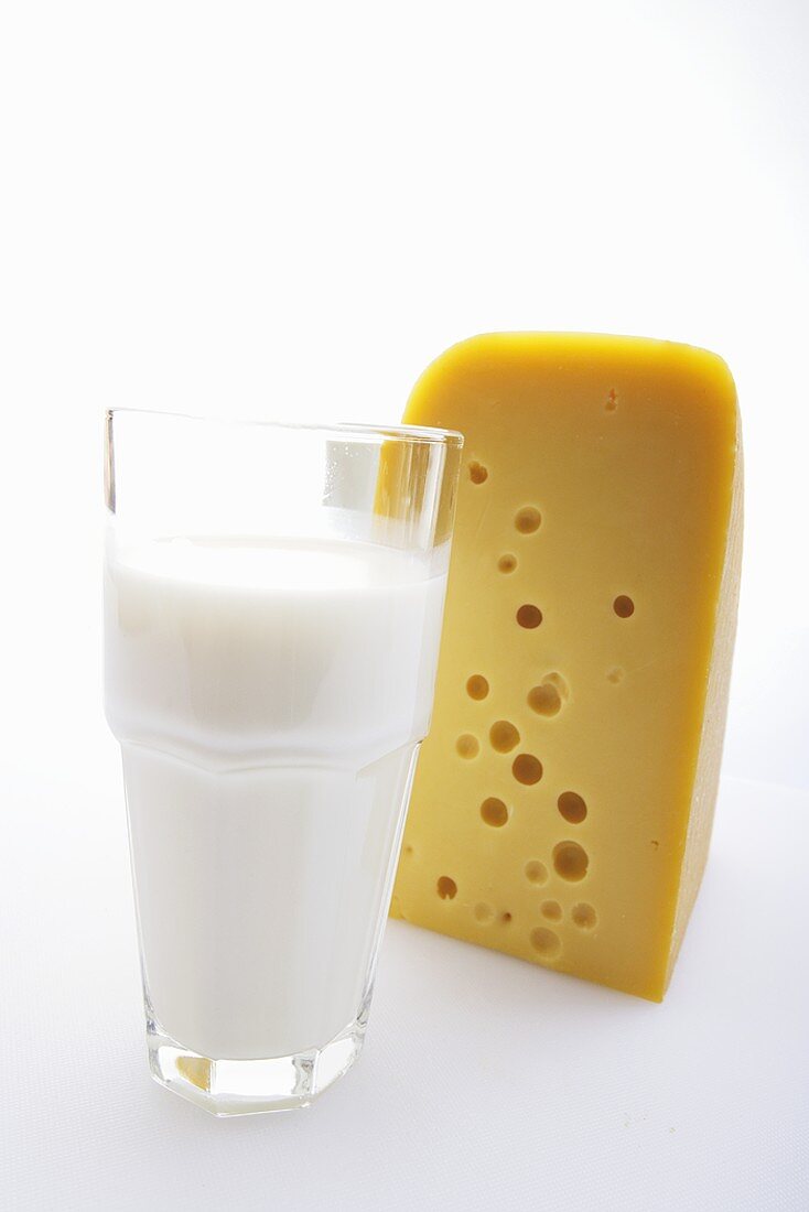A glass of milk and a piece of cheese