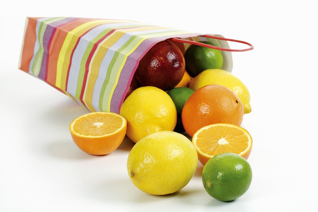 Umgekippte Papiertüte mit Zitrusfrüchten