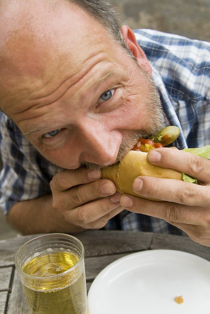 Man biting into a hot dog
