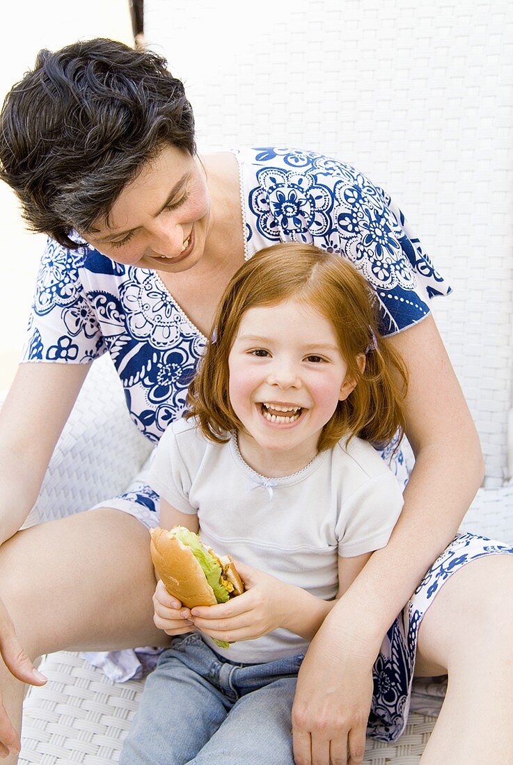 Woman and small girl with hot dog