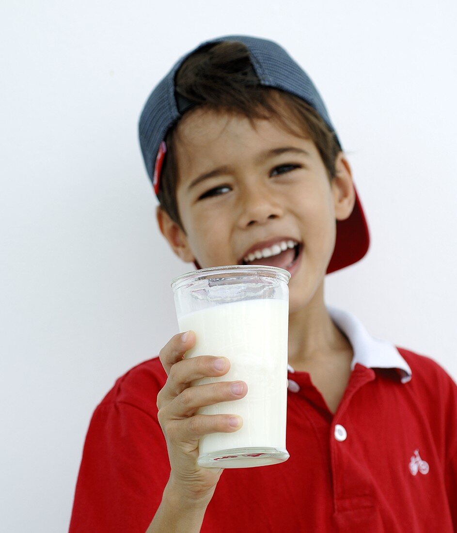 Junge hält ein Glas Milch