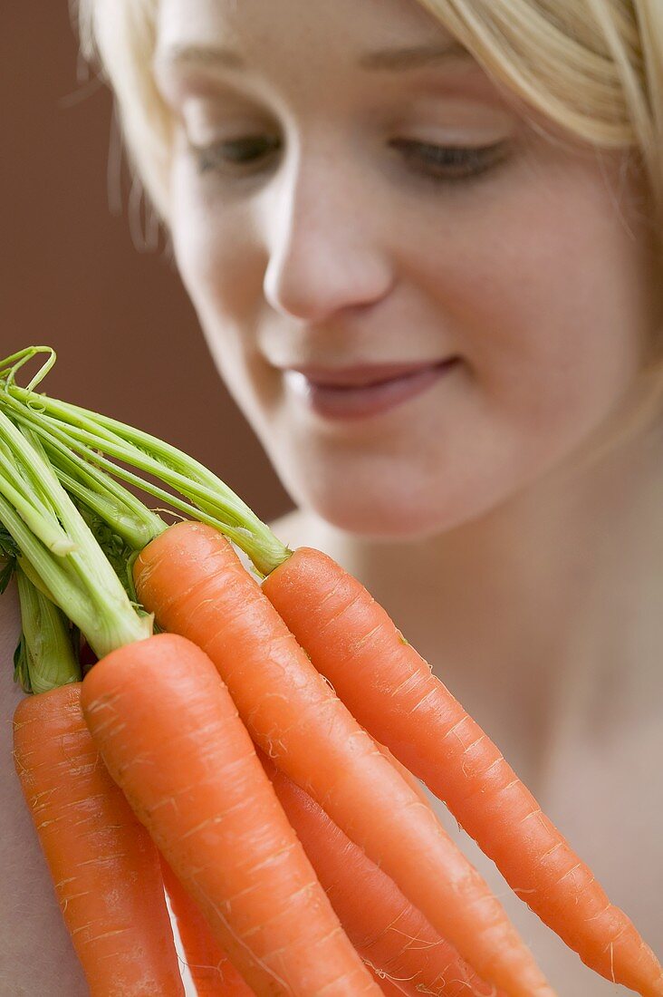 Young woman with carrots