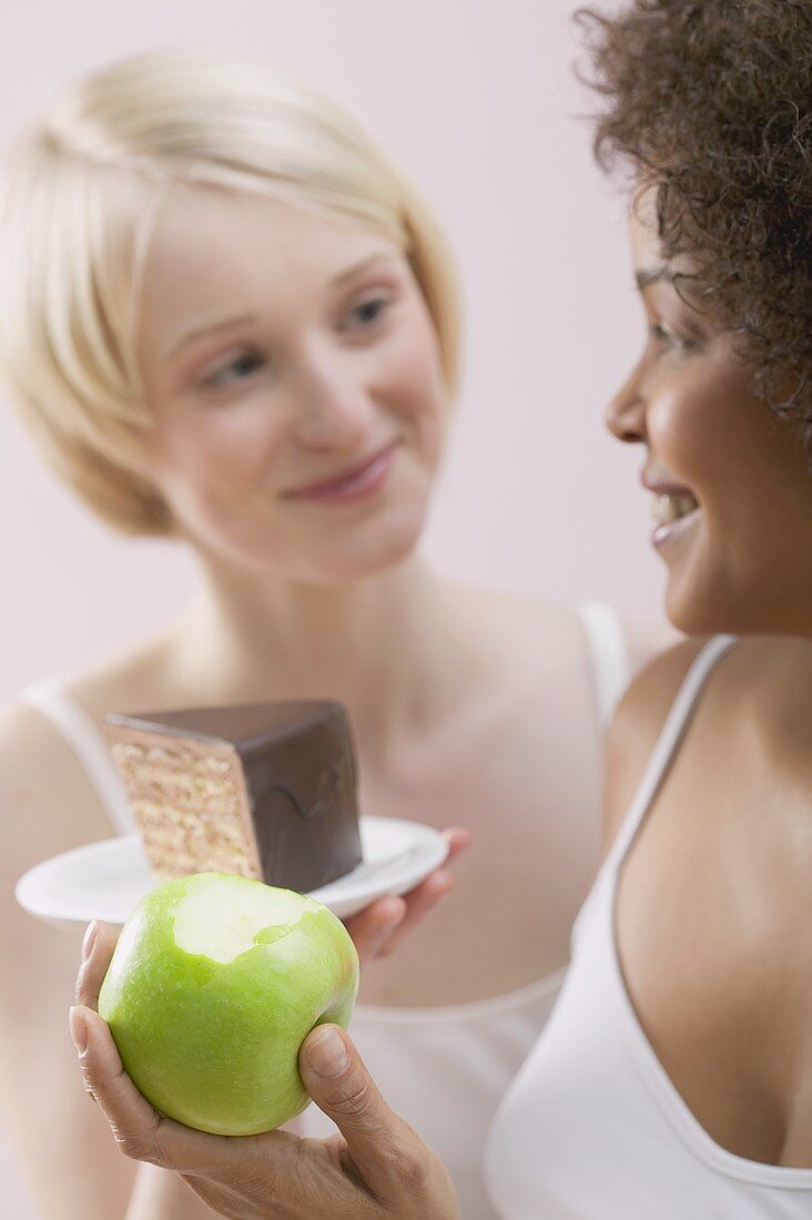 Zwei junge Frauen mit Apfel und Kuchen