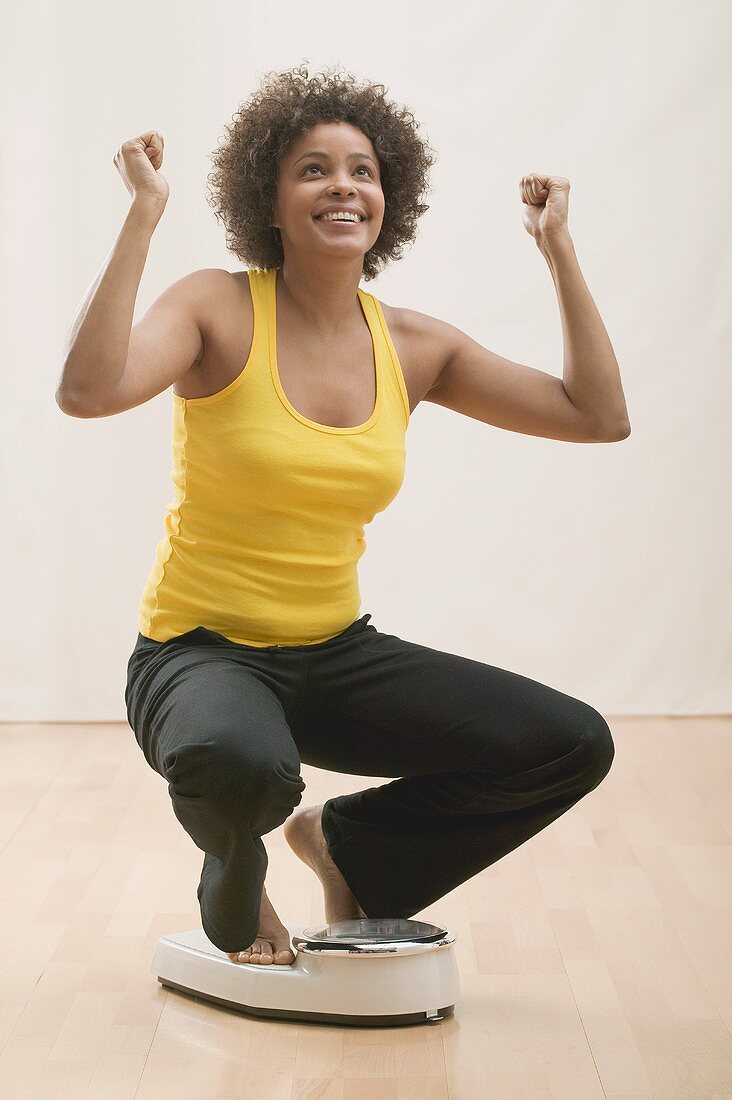 Successful slimming: young woman on scales