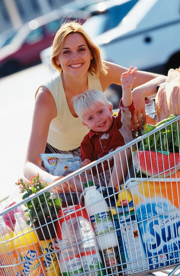 Mutter und Sohn beim Einkauf mit Einkaufswagen