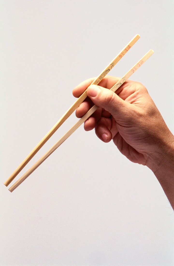 Hand holding chopsticks