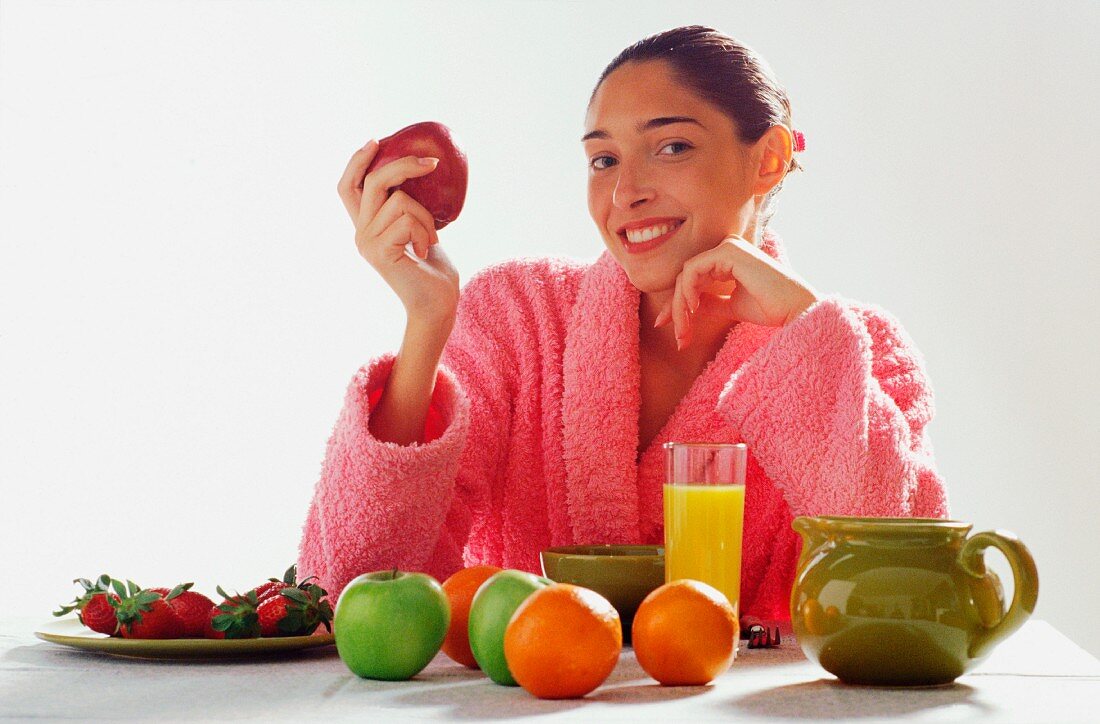 Woman eating fruit in dressing gown
