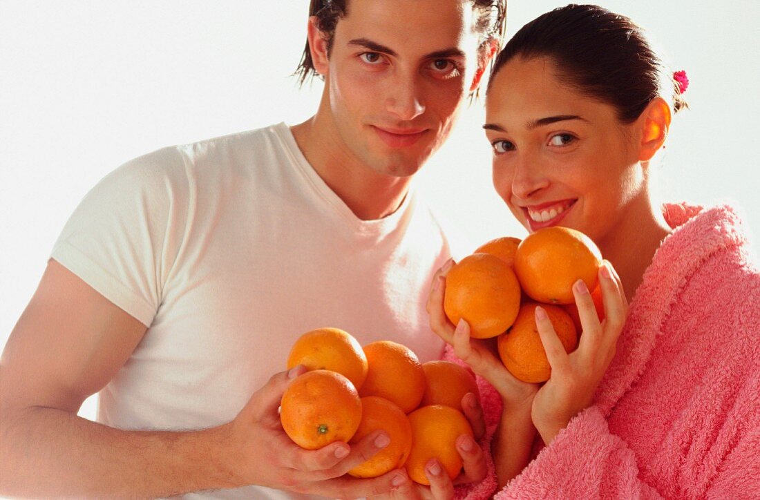 Couple with oranges (healthy diet)