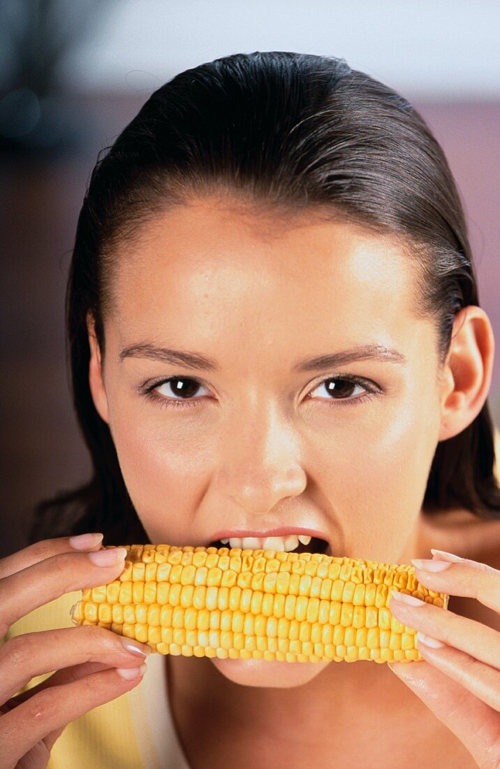 Girl biting into corn on the cob