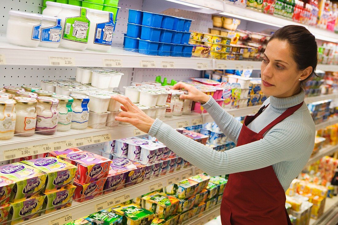 Woman stocking supermarket shelves