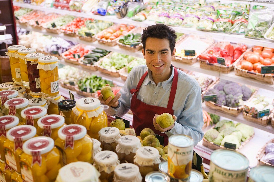 Verkäufer in einem Supermarkt am Regal mit Obst