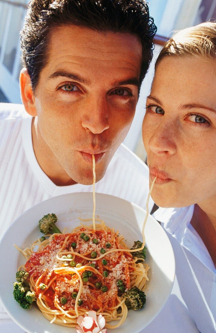 A couple eating spaghetti