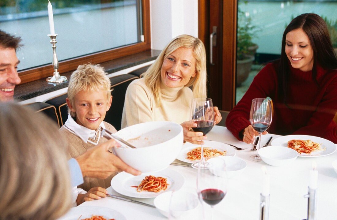 Family eating spaghetti in restaurant