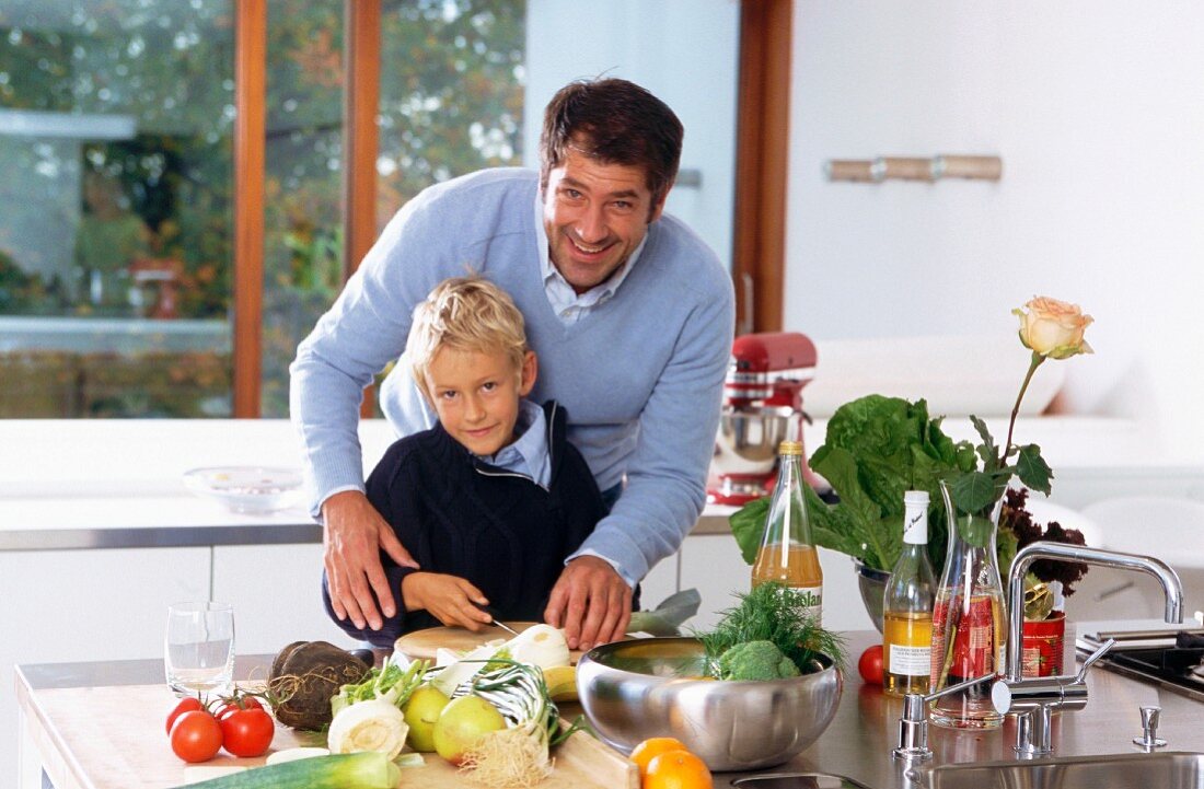 Father and son chopping vegetables in kitchen