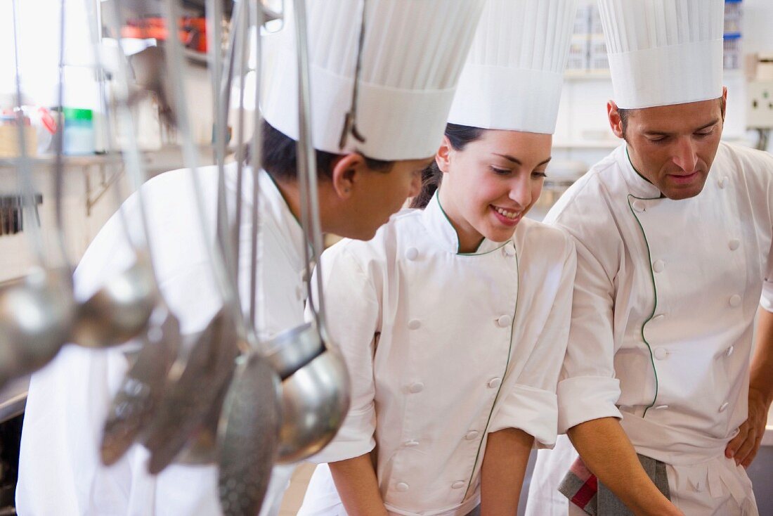 Three chefs in a commercial kitchen