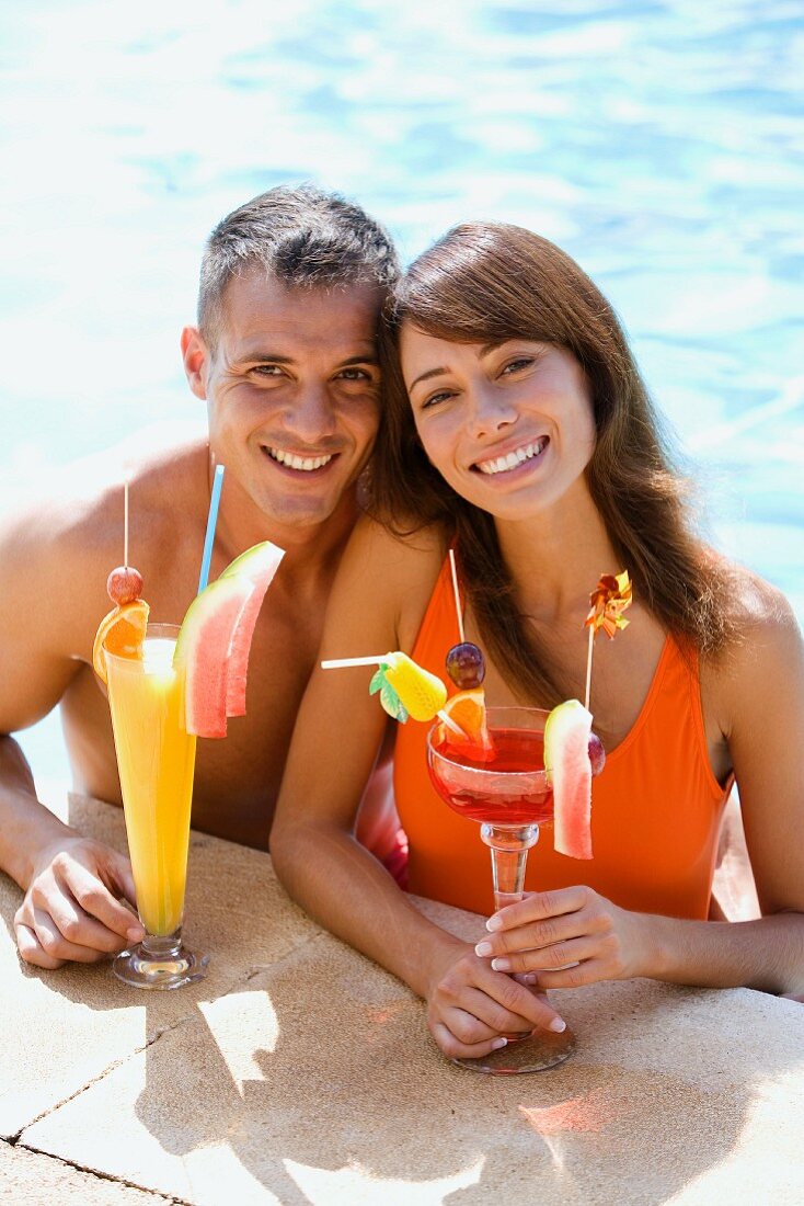 Paar macht Urlaub im Pool mit zwei Cocktails