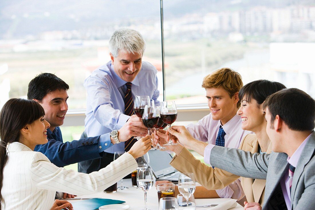 Toasting each other with red wine at a business lunch