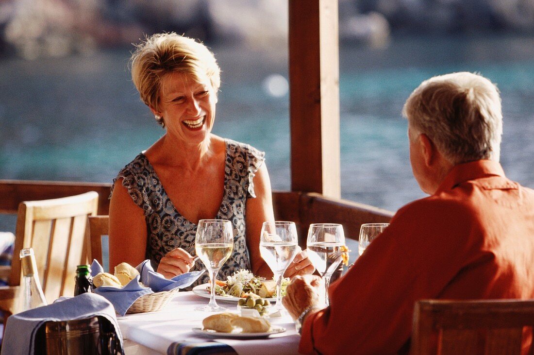 Older married couple dining out on holiday