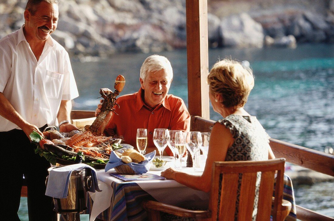 Älteres Ehepaar beim Essen von Hummer im Urlaub