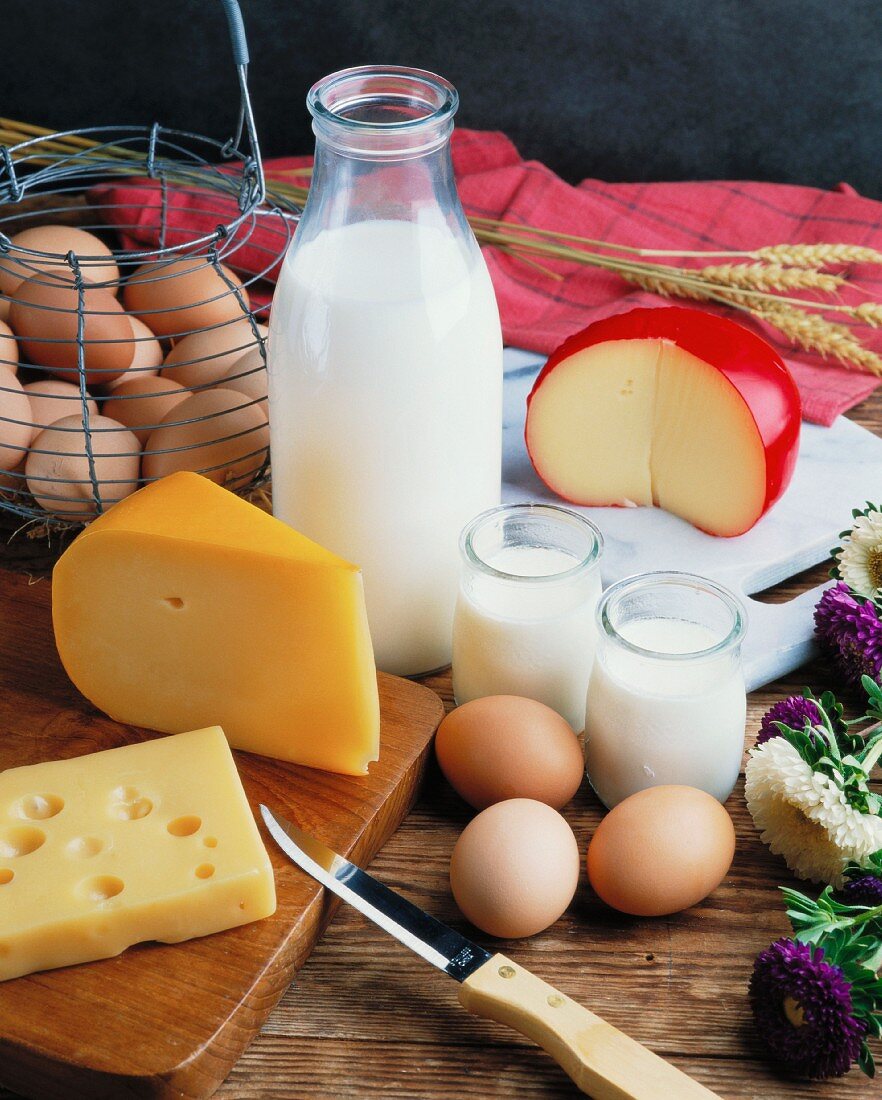 A still life featuring eggs, milk and cheese