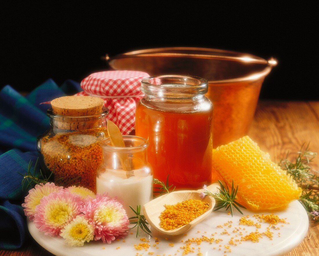 A still life featuring honey, sugar, jam, honeycomb and pollen