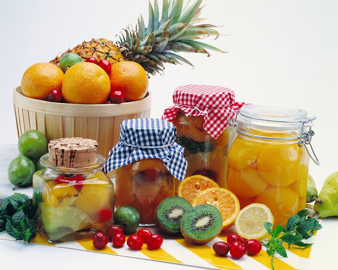 A still life featuring several jars of assorted preserved fruit