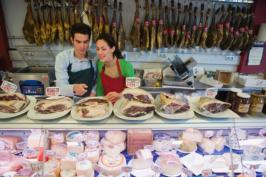 Zwei Verkäufer im Supermarkt hinter der Käse- und Wursttheke