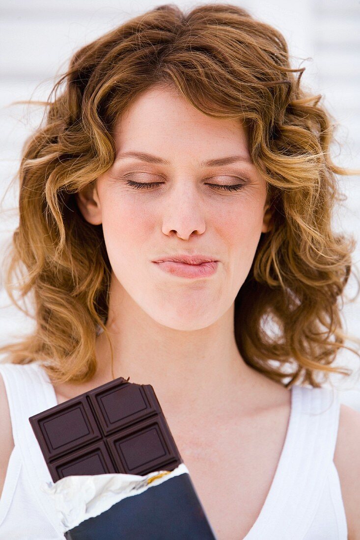 Frau beim Naschen von Schokolade