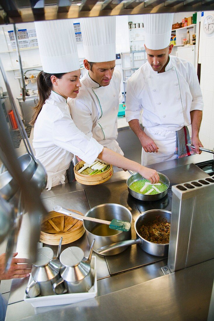 Chefs cooking asparagus in a commercial kitchen