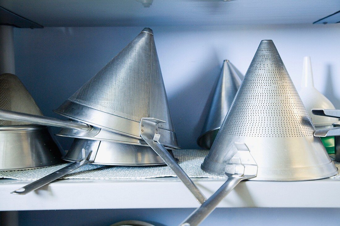 Several pointed sieves on a shelf