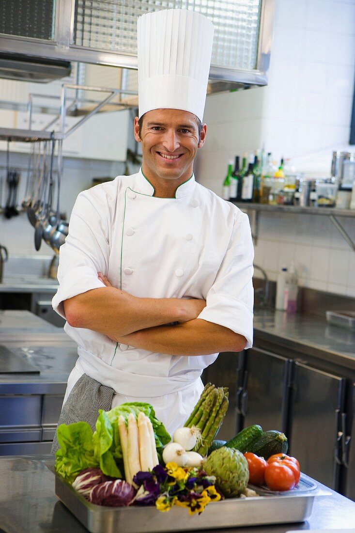 A chef with vegetables in a large kitchen