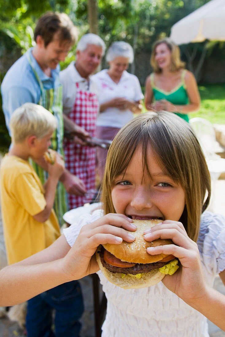 Girl biting into hamburger
