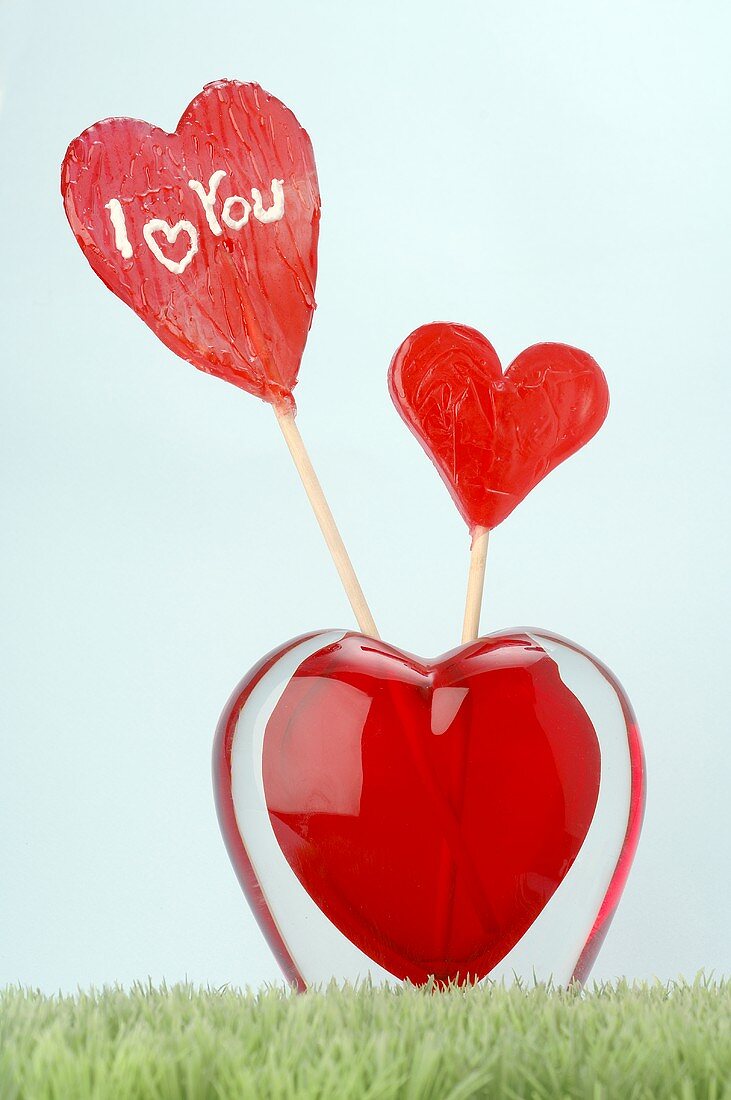 Lollipops in heart-shaped glass vase
