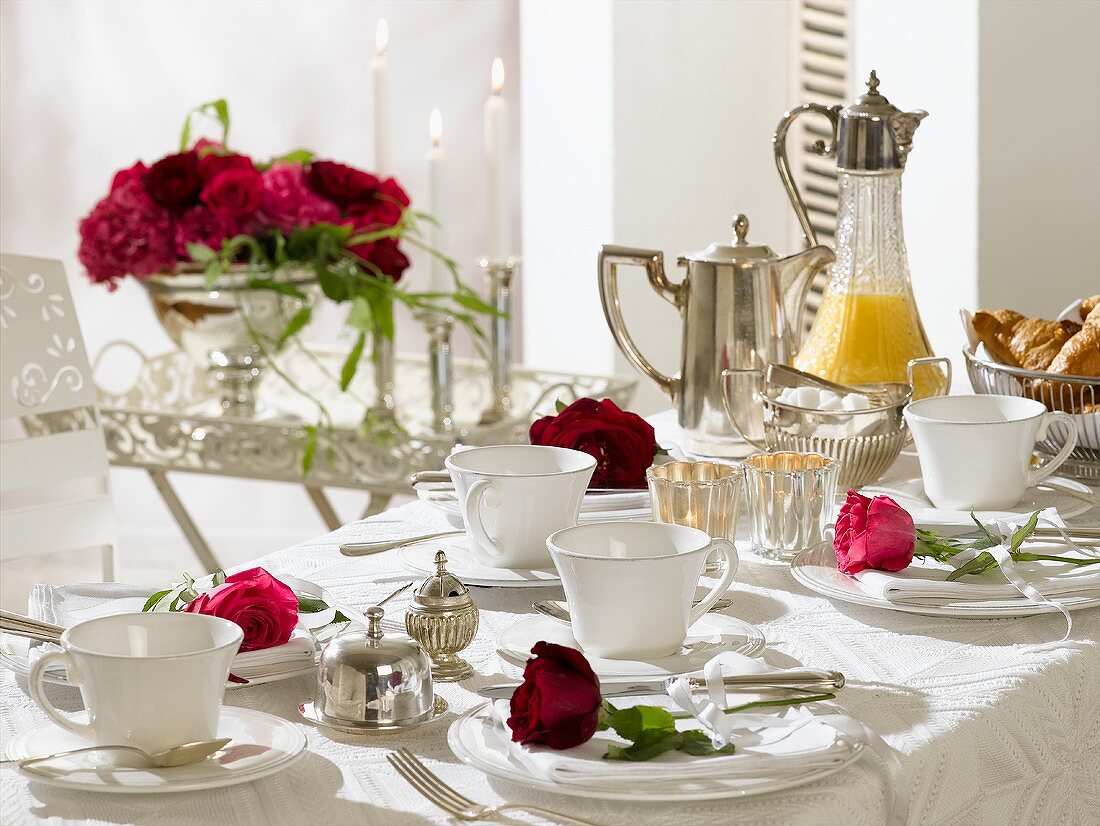 Breakfast table decorated with red roses