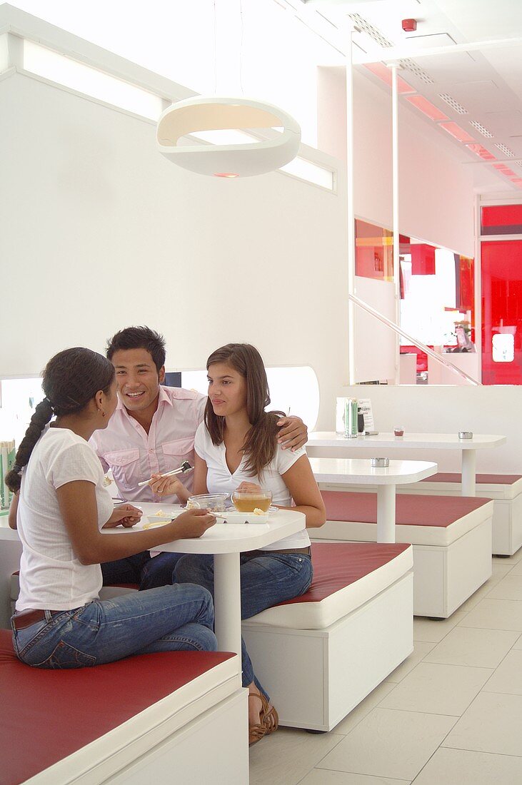 Three young people in a sushi bar