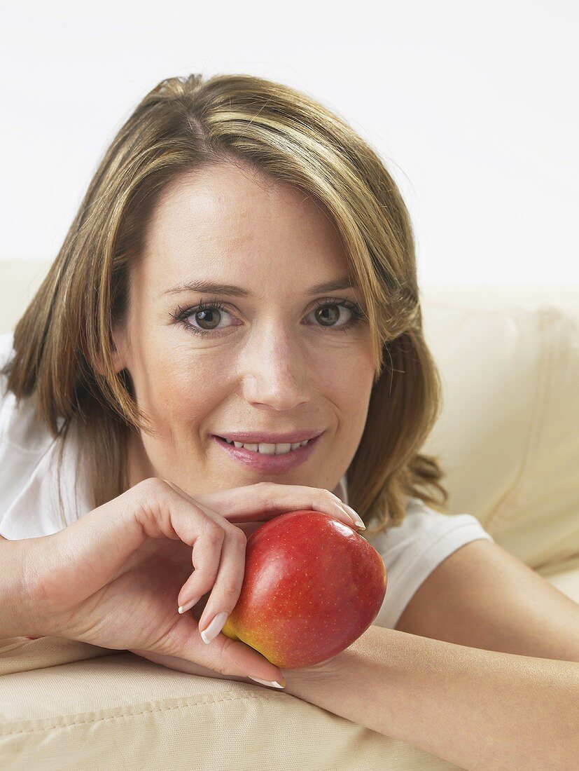 Frau auf dem Sofa mit einem Apfel