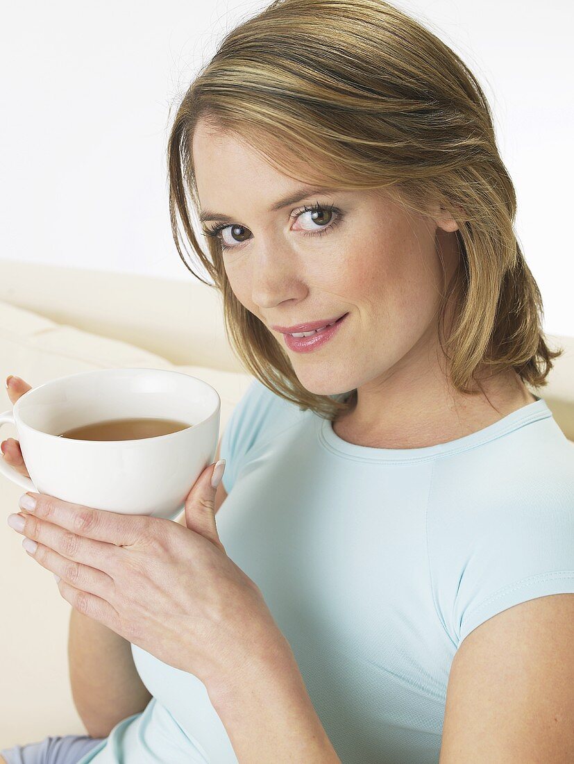 Frau mit einer Tasse Tee auf dem Sofa